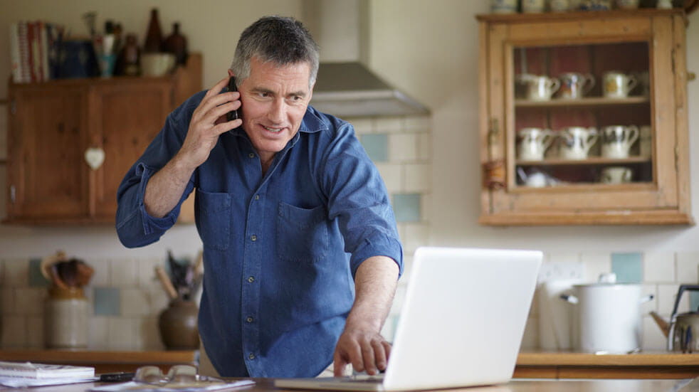 Plan your first motorhome holiday; man on phone and laptop